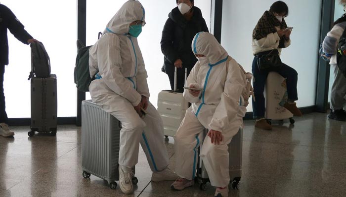 People wearing protective suits wait at a waiting hall of a railway station, after the government eased curbs on the coronavirus disease (COVID-19) control, in Wuhan, Hubei province, China December 11, 2022. — Reuters
