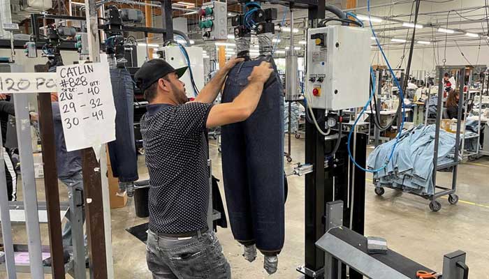 A worker uses a sanding block to distress the surface of new blue jeans at Saitexs factory in Los Angeles, California, U.S. September 21, 2022. — Reuters