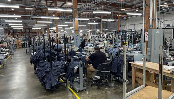 People work at Saitexs factory, which experiments with new robots to cut the cost of making blue jeans, in Los Angeles, California, U.S. September 21, 2022. — Reuters