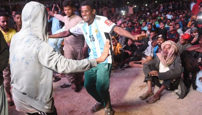 Pakistani football fans dance as they watch the live broadcast of the World Cup semi-final between Argentina and Croatia in the Lyari neighbourhood of Karachi.— AFP