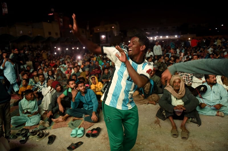 Pakistani football fans dance as they watch the live broadcast of the Qatar 2022 World Cup football semi-final match between Argentina and Croatia in the Lyari neighbourhood of Karachi on December 14, 2022.