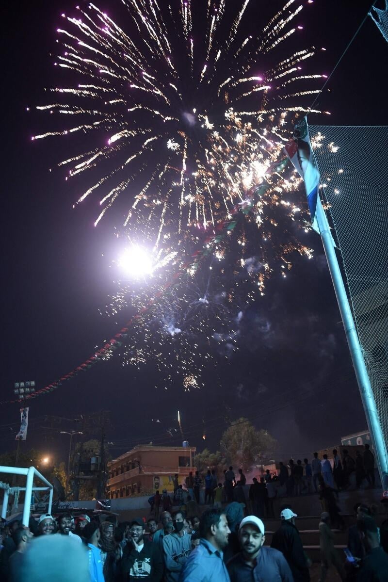 Fireworks explode over Pakistani football fans watching the live broadcast of the Qatar 2022 World Cup football semi-final match between Argentina and Croatia in the Lyari neighbourhood of Karachi on December 14, 2022.