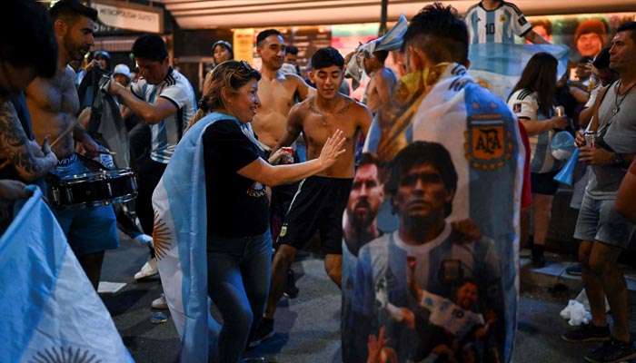 Fans of Argentina celebrate their team´s victory after the Qatar 2022 World Cup semifinal football match between Croatia and Argentina at the Obelisk in Buenos Aires on December 13, 2022. —