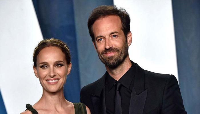 Natalie Portman beams as she snuggles up to husband Benjamin Millepied in Paris