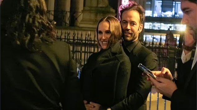 Natalie Portman beams as she snuggles up to husband Benjamin Millepied in Paris