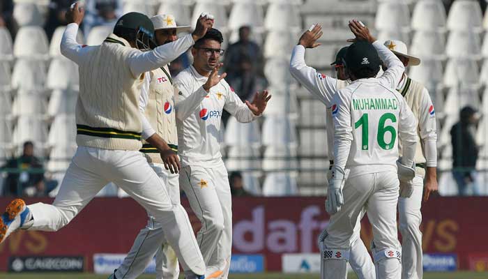 Pakistans Abrar Ahmed (3L) celebrates with teammates after taking the wicket of Englands Ollie Robinson (not pictured) during the third day of the second cricket Test match between Pakistan and England at the Multan Cricket Stadium in Multan on December 11, 2022.