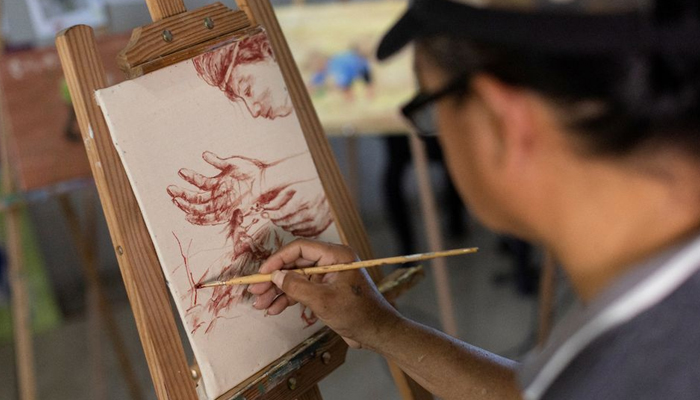Filipino artist Elito Circa, 52, paints with his own blood in his studio in Nueva Ecija province, Philippines, November 29, 2022. REUTERS