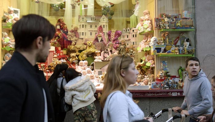 The picture shows residents walking in front of a toy shop. — AFP