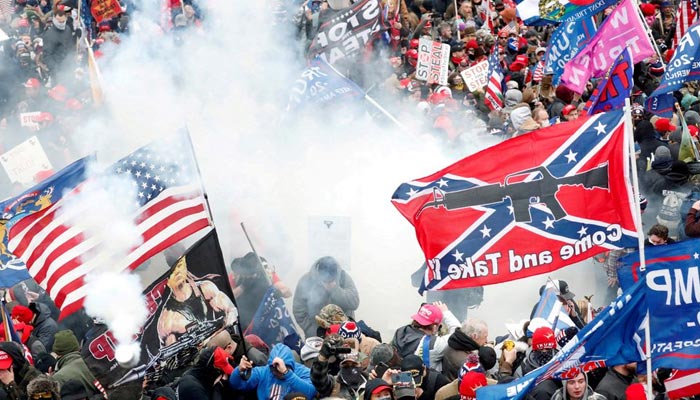 Tear gas is released into a crowd of protesters, with one wielding a Confederate battle flag that reads Come and Take It, during clashes with Capitol police at a rally to contest the certification of the 2020 US presidential election results by the US Congress, at the US Capitol Building in Washington, US, January 6, 2021. — Reuters