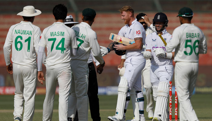 Englands captain Ben Stokes shakes hands with Pakistani players after winning the third Test at National Stadium Karachi. — Reuters
