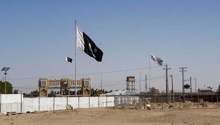General view of Pakistans flag and the Talibans flag in the background as seen from the Friendship Gate crossing point in the Pakistan-Afghanistan border town of Chaman, August 12, 2021. —Reuters