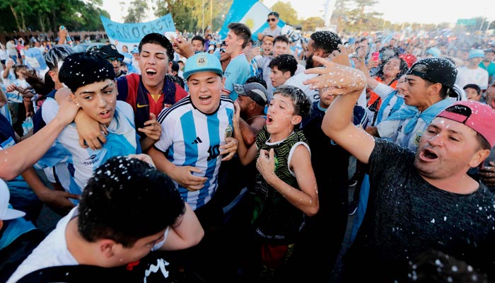 Fans Argentina bersorak saat menunggu kedatangan tim setelah memenangkan pertandingan sepak bola final Piala Dunia FIFA Qatar 2022 melawan Prancis, di Ezeiza, provinsi Buenos Aires, Argentina, pada 19 Desember 2022. — AFP