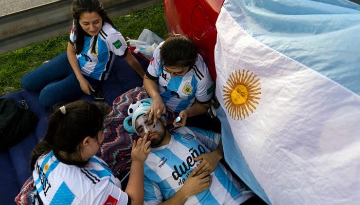 Fans Argentina menunggu kedatangan para pemain ke negara mereka setelah memenangkan pertandingan sepak bola final Piala Dunia FIFA Qatar 2022 melawan Prancis di Ezeiza, provinsi Buenos Aires, Argentina, pada 19 Desember 2022. — AFP