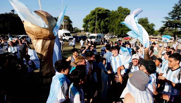Fans Argentina bersorak saat menunggu kedatangan tim setelah memenangkan pertandingan sepak bola final Piala Dunia FIFA Qatar 2022 melawan Prancis, di Ezeiza, provinsi Buenos Aires, Argentina, pada 19 Desember 2022. — AFP