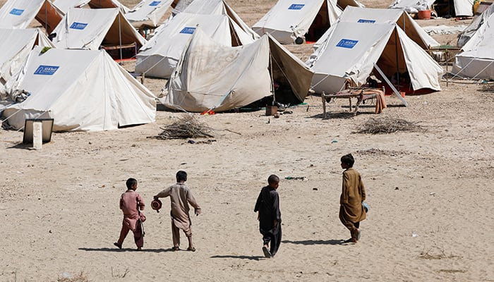Displaced children walk outside their family tents in a camp, following rains and floods during the monsoon season in Sehwan, Pakistan, September 16, 2022. — Reuters