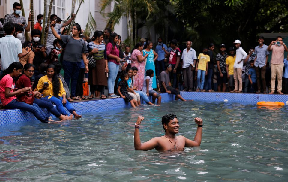 A man stands in the swimming pool as people visit the Presidents house on the day after demonstrators entered the building, after President Gotabaya Rajapaksa fled, amid the countrys economic crisis, in Colombo, Sri Lanka July 10, 2022. — Reuters