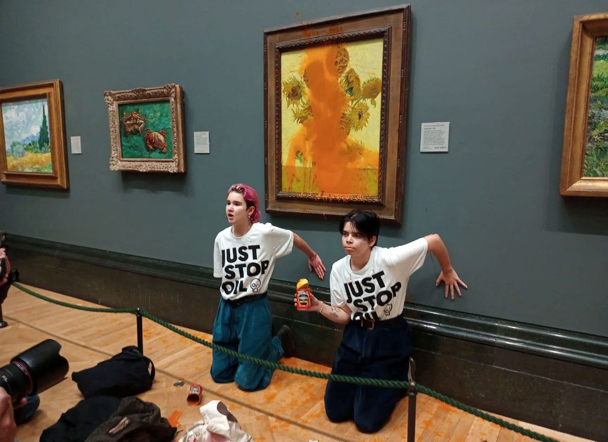 Activists of Just Stop Oil glue their hands to the wall after throwing soup at a van Goghs painting Sunflowers at the National Gallery in London, Britain October 14, 2022. — Reuters