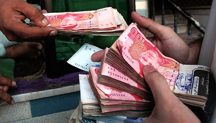 An undated image of a currency dealer collecting Pakistani notes. — Reuters/File