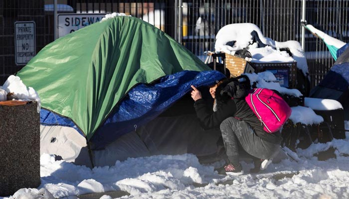 A woman looks on outside of a tent in downtown during a period of cold weather in Denver, Colorado, U.S. December 22, 2022. — Reuters