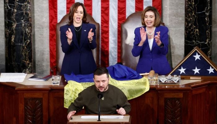 Ukraines President Volodymyr Zelenskiy addresses a joint meeting of the US Congress while US House Speaker Nancy Pelosi (D-CA) and US Vice President Kamala Harris applaud, as a US flag and Ukrainian flag are pictured on the table, in the House Chamber of the US Capitol in Washington, US, December 21, 2022.— Reuters