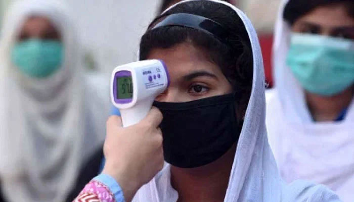 A health worker check a temperature of a student. — AFP/File