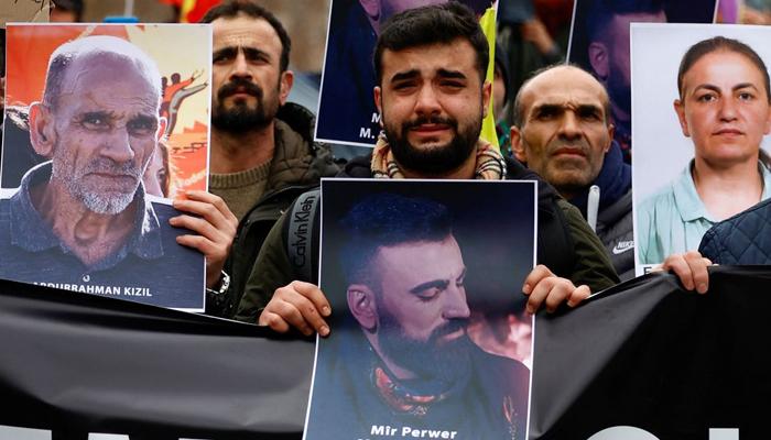 A man reacts while holding a photograph of Mir Perwer who was killed in a shooting — REUTERS