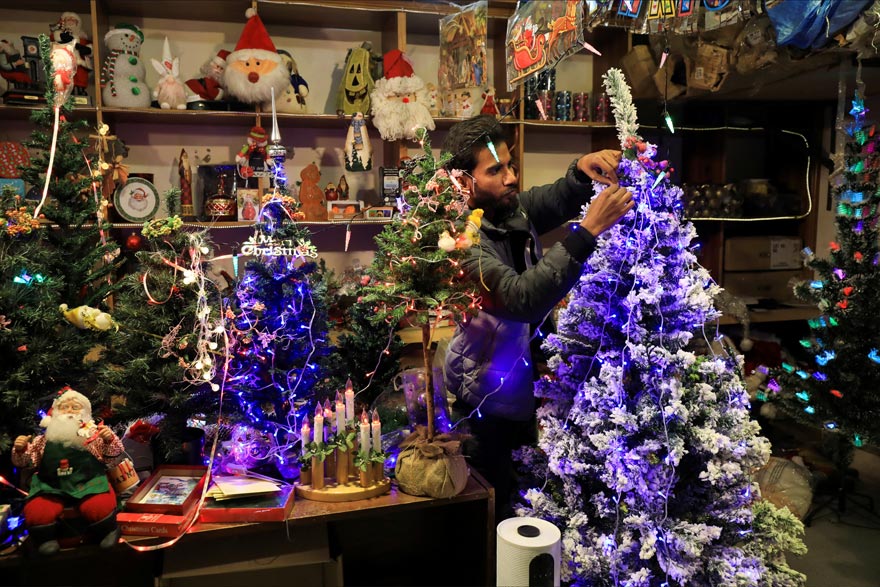 ایک شخص 22 دسمبر 2022 کو پشاور، پاکستان میں کرسمس کی تقریبات سے پہلے سینٹ جانز کیتھیڈرل میں مختلف آرائشی اشیاء کے ساتھ ایک دکان پر کرسمس کی سجاوٹ کر رہا ہے۔ — رائٹرز