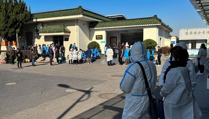 People wearing personal protective equipment (PPE) stand outside a funeral home, as coronavirus disease (COVID-19) outbreak continues, in Shanghai, China December 24, 2022. — Reuters