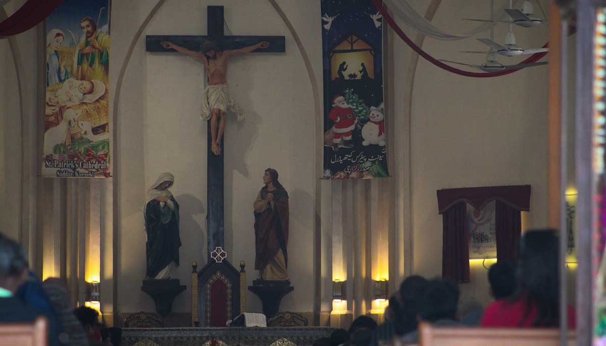 Devotees sit across the St. Patricks Cathedrals altar.