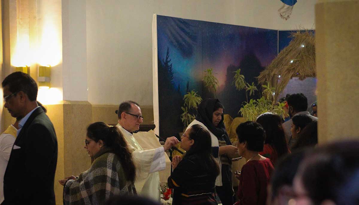 Father James Borges, the priest who led the Christmas Day mass at St. Patricks Cathedral, distribute the Holy Communion after prayers for the day complete on December 25.