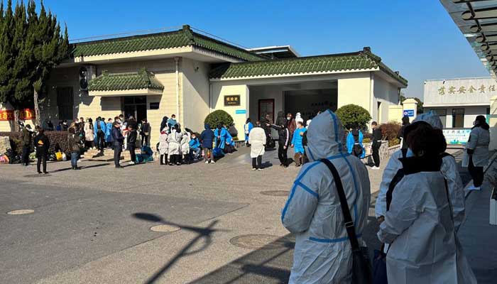 People wearing personal protective equipment (PPE) stand outside a funeral home, as coronavirus disease (COVID-19) outbreak continues, in Shanghai, China December 24, 2022. — Reuters