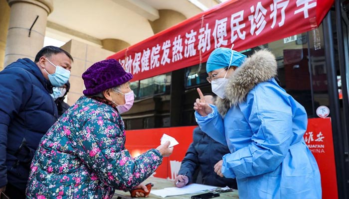 medical worker provides instructions to a resident at a mobile fever clinic converted from a bus amid the coronavirus disease (COVID-19) outbreak, in Huaian, Jiangsu province, China December 25, 2022. — Reuters