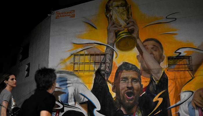 A mural by artist Maxi Bagnasco depicting Argentina´s captain and forward Lionel Messi raising the FIFA World Cup Trophy next to his teammates after winning the Qatar 2022 World Cup tournament is seen in Buenos Aires. — AFP