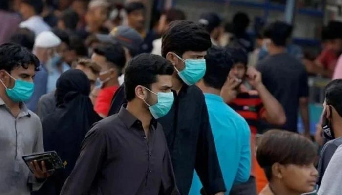 Men wearing protective face masks walk amid the rush of people outside a market during an outbreak of the coronavirus disease (COVID-19) continues, in Karachi, Pakistan June 8, 2020. — Reuters/File