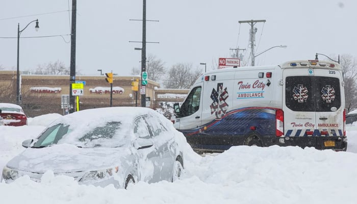 An ambulance passes an abandoned car during a winter storm that hit the Buffalo region — Reuters