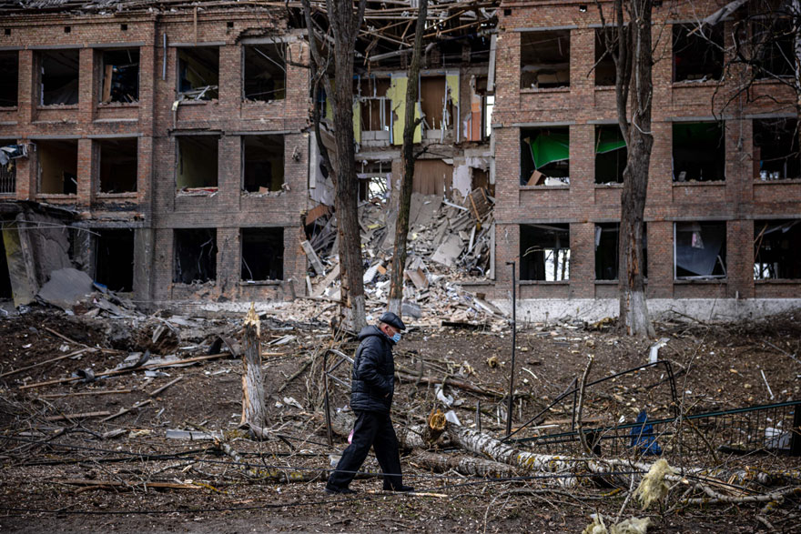 ایک شخص 27 فروری 2022 کو کیف کے قریب واقع قصبے واسلکیو میں روسی میزائل حملے کے بعد تباہ شدہ عمارت کے سامنے سے گزر رہا ہے۔ — اے ایف پی