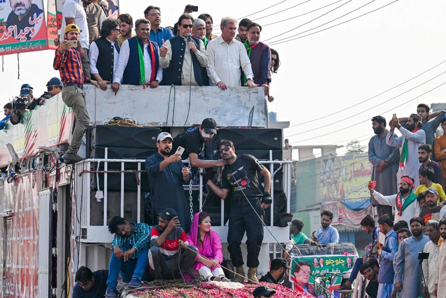 Former Pakistan prime minister Imran Khan (C) addresses his supporters during an anti-government long march towards Islamabad to demand early elections, in Lahore on October 29, 2022. — AFP