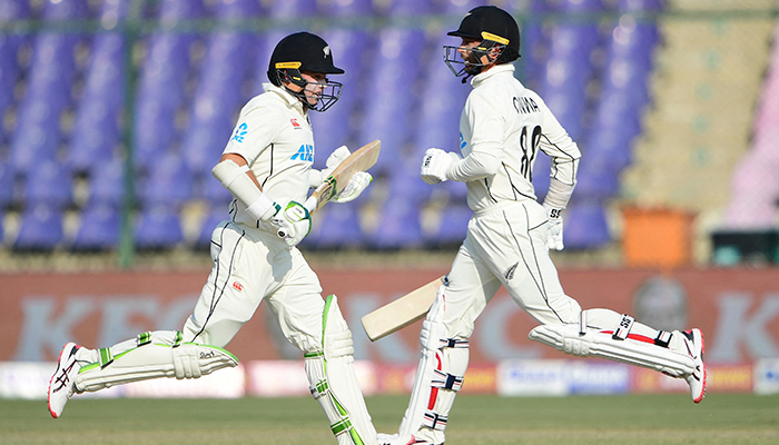 New Zealands Devon Conway (R) and Tom Latham run between the wickets during the second day of the first cricket Test match between Pakistan and New Zealand at the National Stadium in Karachi on December 27, 2022. — AFP