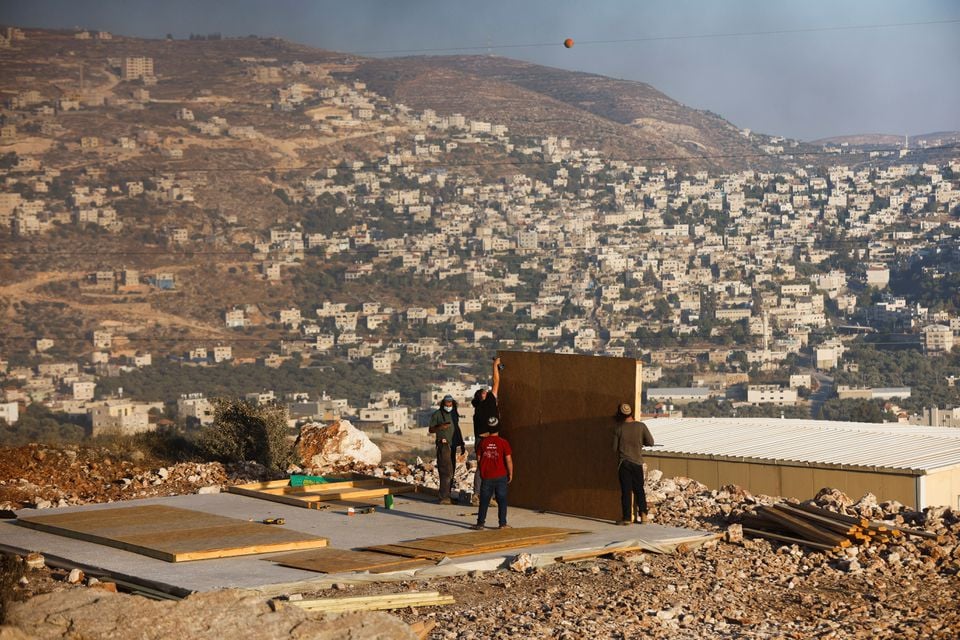 Jewish settlers youths construct a structure in Givat Eviatar, a new Israeli settler outpost, near the Palestinian village of Beita in West Bank, June 23, 2021. — Reuters