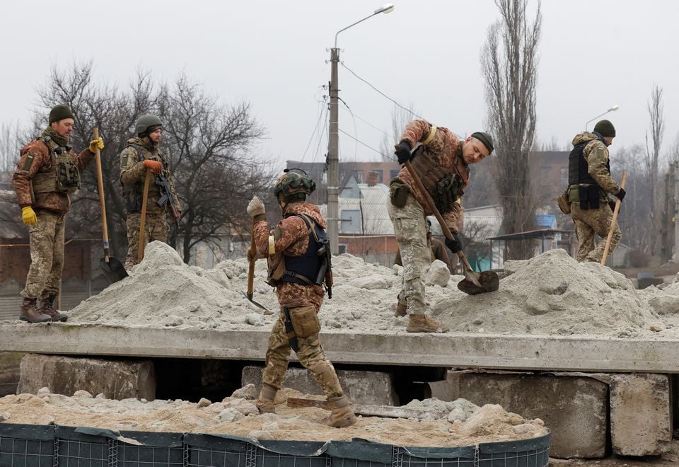 Ukrainian soldiers build a bunker with sand, as Russia's attack on Ukraine continues, during intense shelling in Bakhmut, Ukraine, December 26, 2022. — Reuters