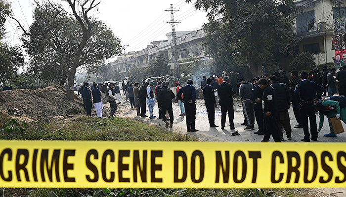 پولیس اہلکار 23 دسمبر 2022 کو اسلام آباد میں خودکش دھماکے کی جگہ پر جمع ہیں۔ - اے ایف پی