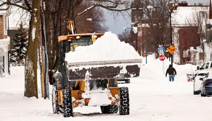27 دسمبر 2022 کو بفیلو، نیو یارک، یو ایس میں موسم سرما کے طوفان کے بعد ایک فرنٹ لوڈر سڑک سے برف ہٹا رہا ہے۔ - رائٹرز