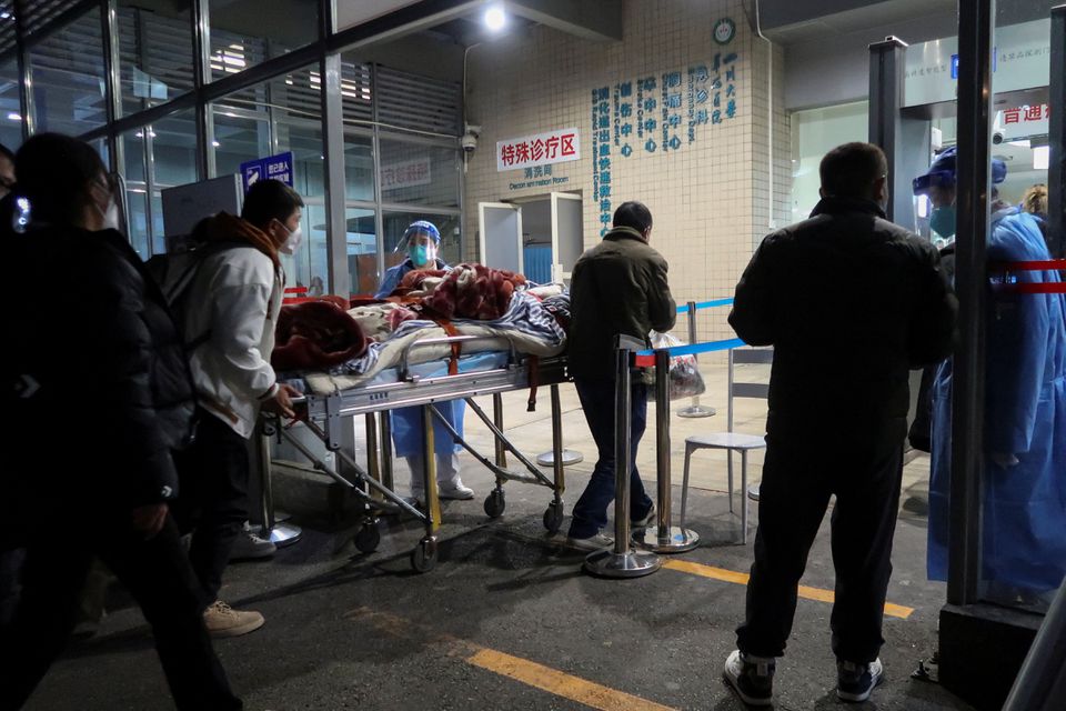27 دسمبر 2022 کو چین کے صوبہ سیچوان کے چینگڈو میں، کورونا وائرس کی بیماری (COVID-19) کے پھیلنے کے دوران، لوگ ایک بزرگ مریض کو ہسپتال کے ایمرجنسی ڈیپارٹمنٹ کے باہر اسٹریچر پر لے جا رہے ہیں۔ — رائٹرز