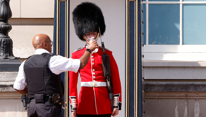 A member of the Queens Guard receives water to drink during the hot weather, outside Buckingham Palace in London, Britain, July 18, 2022. — Reuters