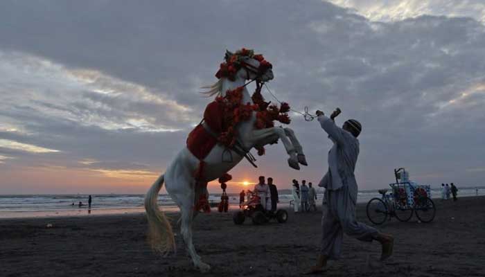Photograph of a horse and its owner at the Seaview beach in Karachi. — Reuters/File