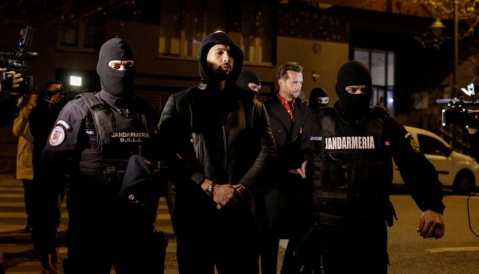 Andrew Tate and Tristan Tate are escorted by police officers outside the headquarters of the Directorate for Investigating Organized Crime and Terrorism in Bucharest (DIICOT) after being detained for 24 hours, in Bucharest, Romania, December 29, 2022.— Reuters