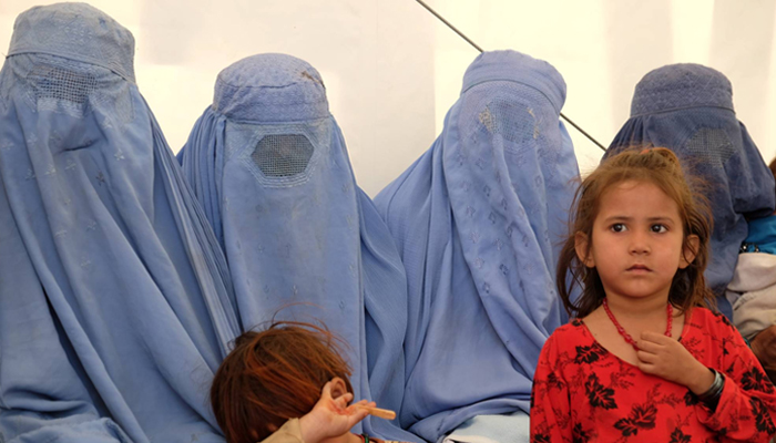 In this file photo, Afghan women and children can be seen sitting. — Reuters
