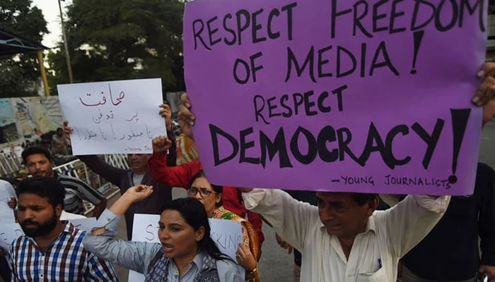 Pakistani journalists and civil society activists hold placards against the attack on a senior journalist of a local newspaper in Karachi on October 28, 2017. — AFP