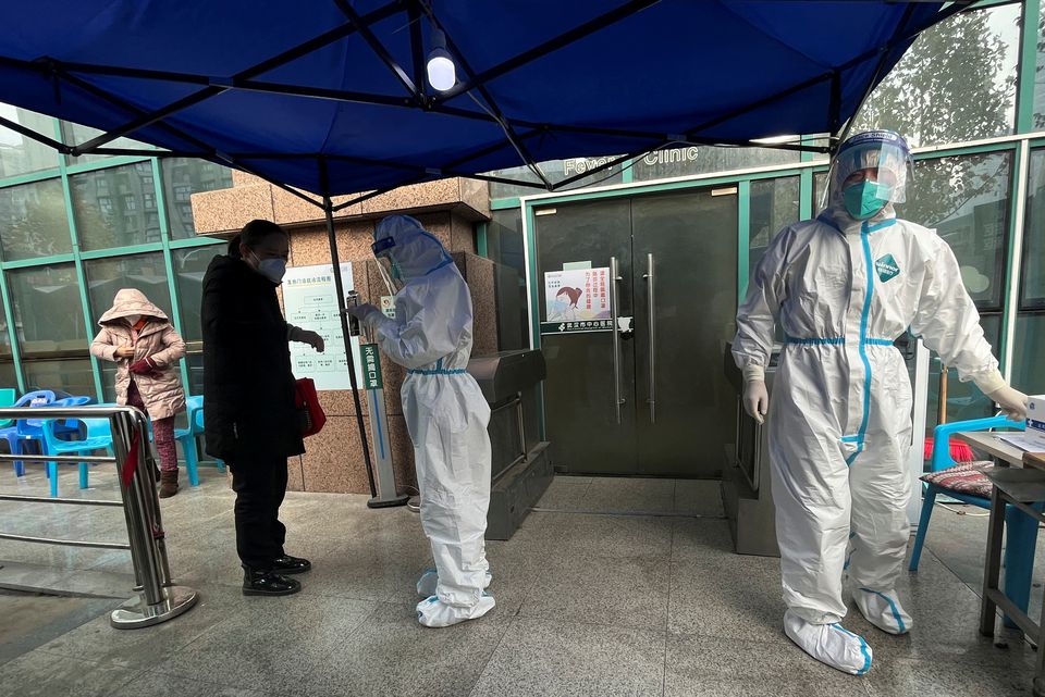A medical worker in a protective suit checks a thermometer for a patient at the entrance to the fever clinic of the Central Hospital of Wuhan, amid of the coronavirus disease (COVID-19) outbreak, in Wuhan, Hubei province, China December 31, 2022.— Reuters