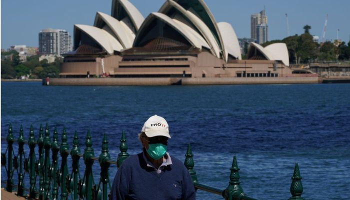A person in protective face mask walks along the harbour waterfront across from the Sydney Opera House in Sydney, Australia, October 6, 2021.— Reuters